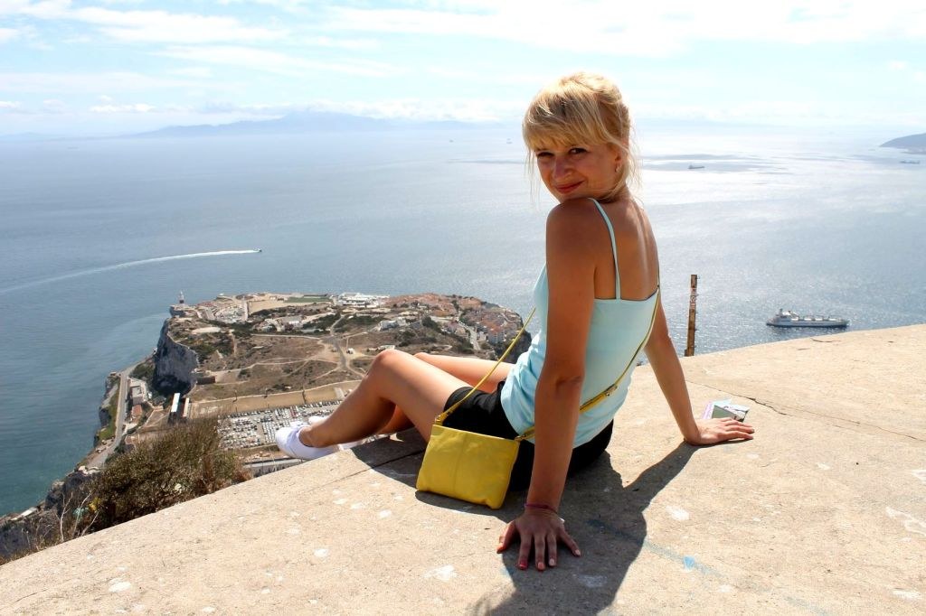 a_blond_girl_sitting_on_the_edge_of_gibraltar