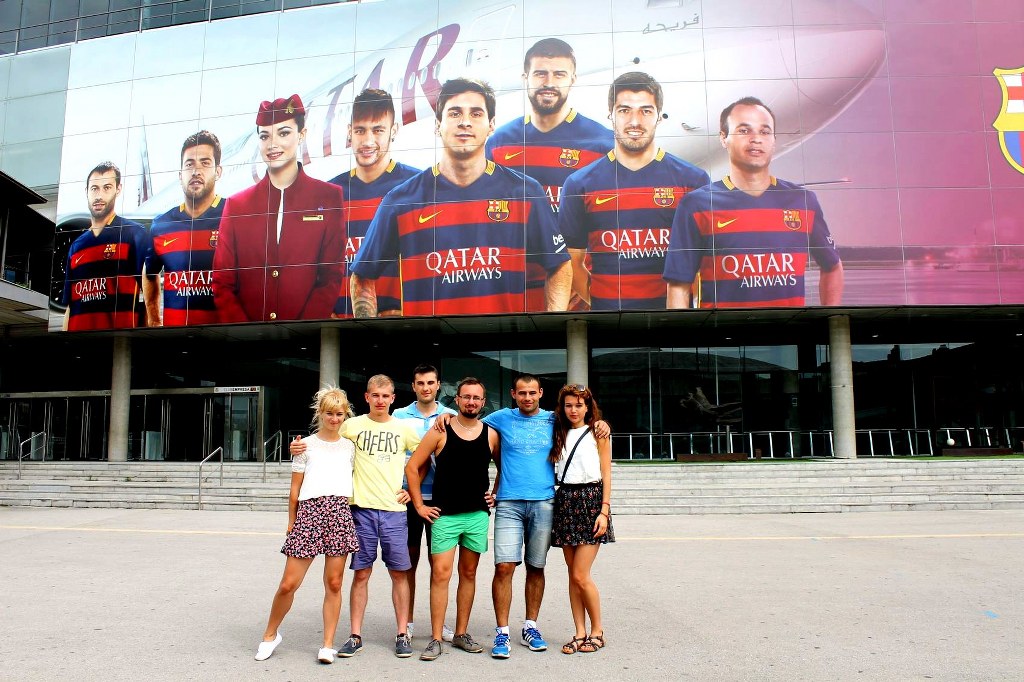 a_group_of_friends_standing_in_front_of_fc_barcelona_stadium