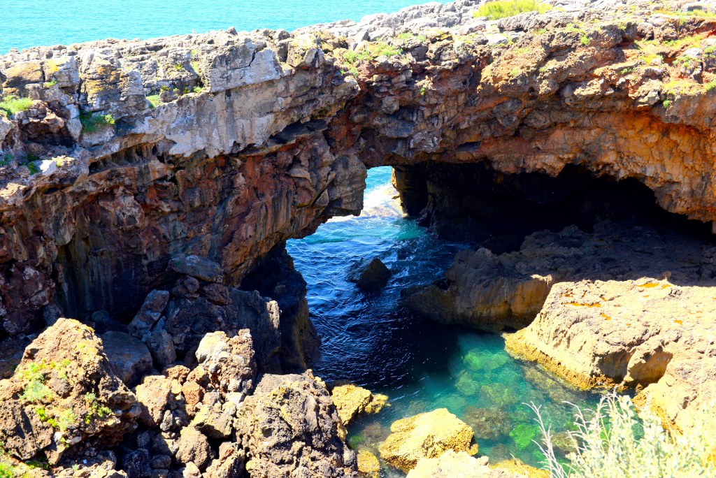 blue_water_flowing_beneath_rocky_coast_in_portugal