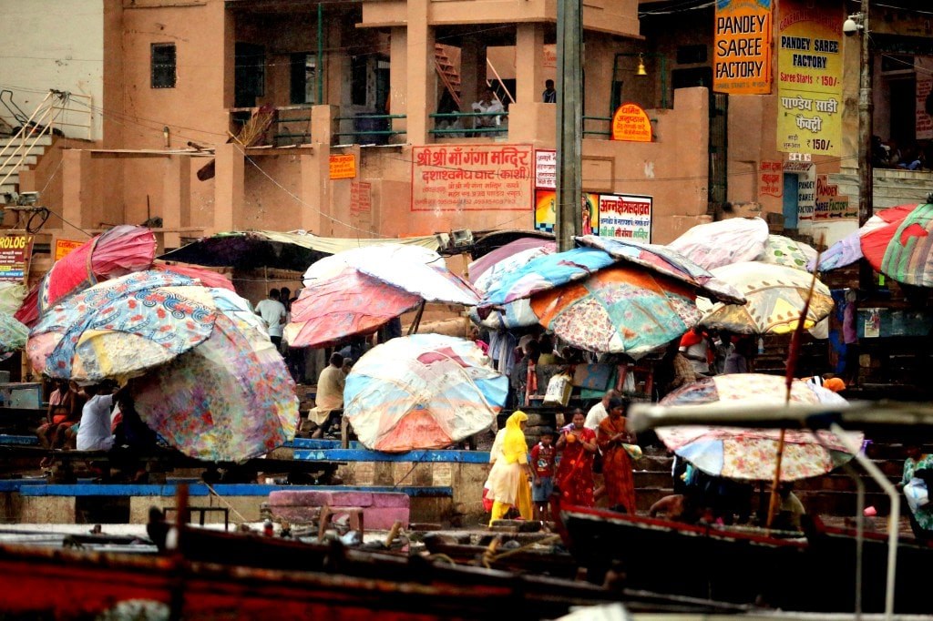 people_sheltering_from_rain_using_huge_colorful_umbrellas