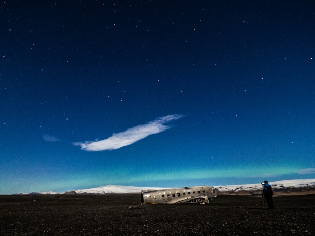 northern light near an airplane wreck in iceland