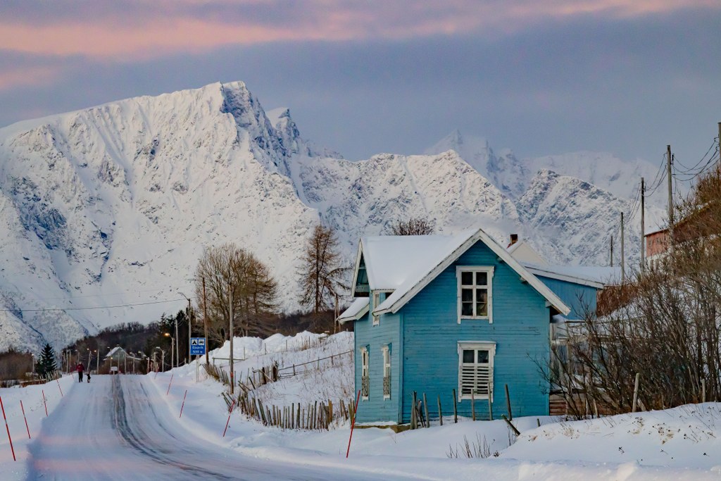 a_blue_wooden_house_in_a_snowy_mountain_area